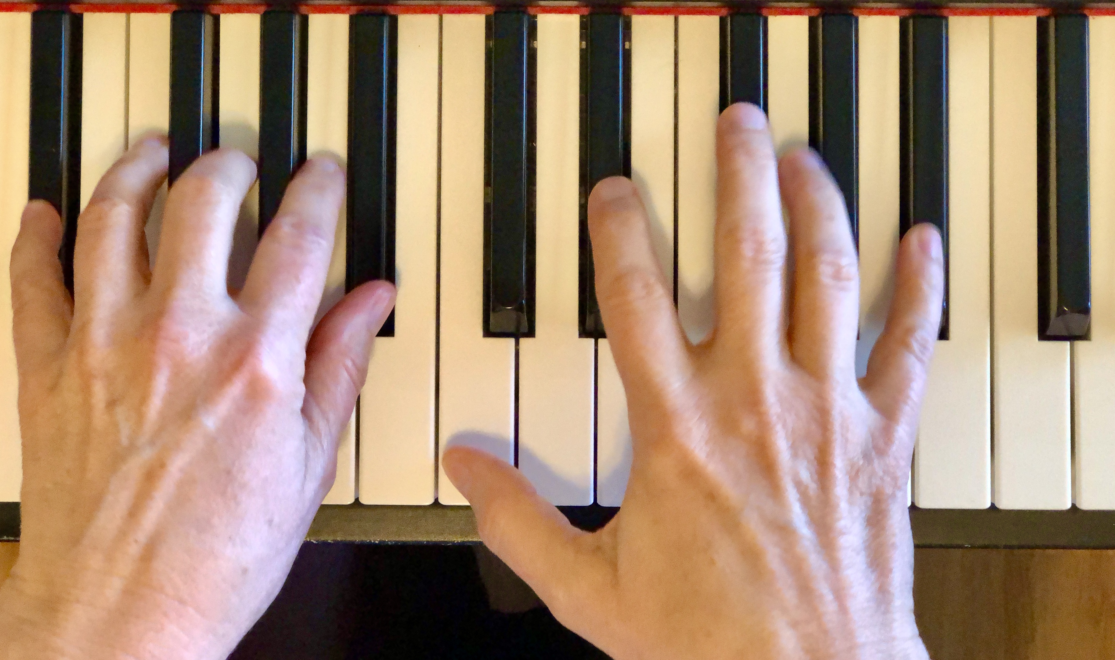 hands on piano keyboard in playing position